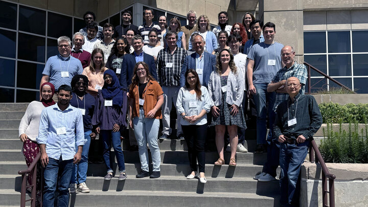 About 35 people pose on a staircase outside the Beadle Center.