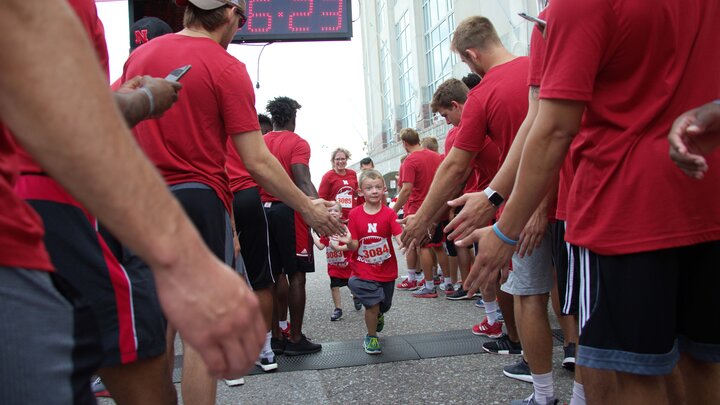 Nebraska athletes greet participants in the Nebraska Football Road Race. The seventh-annual event is July 14.